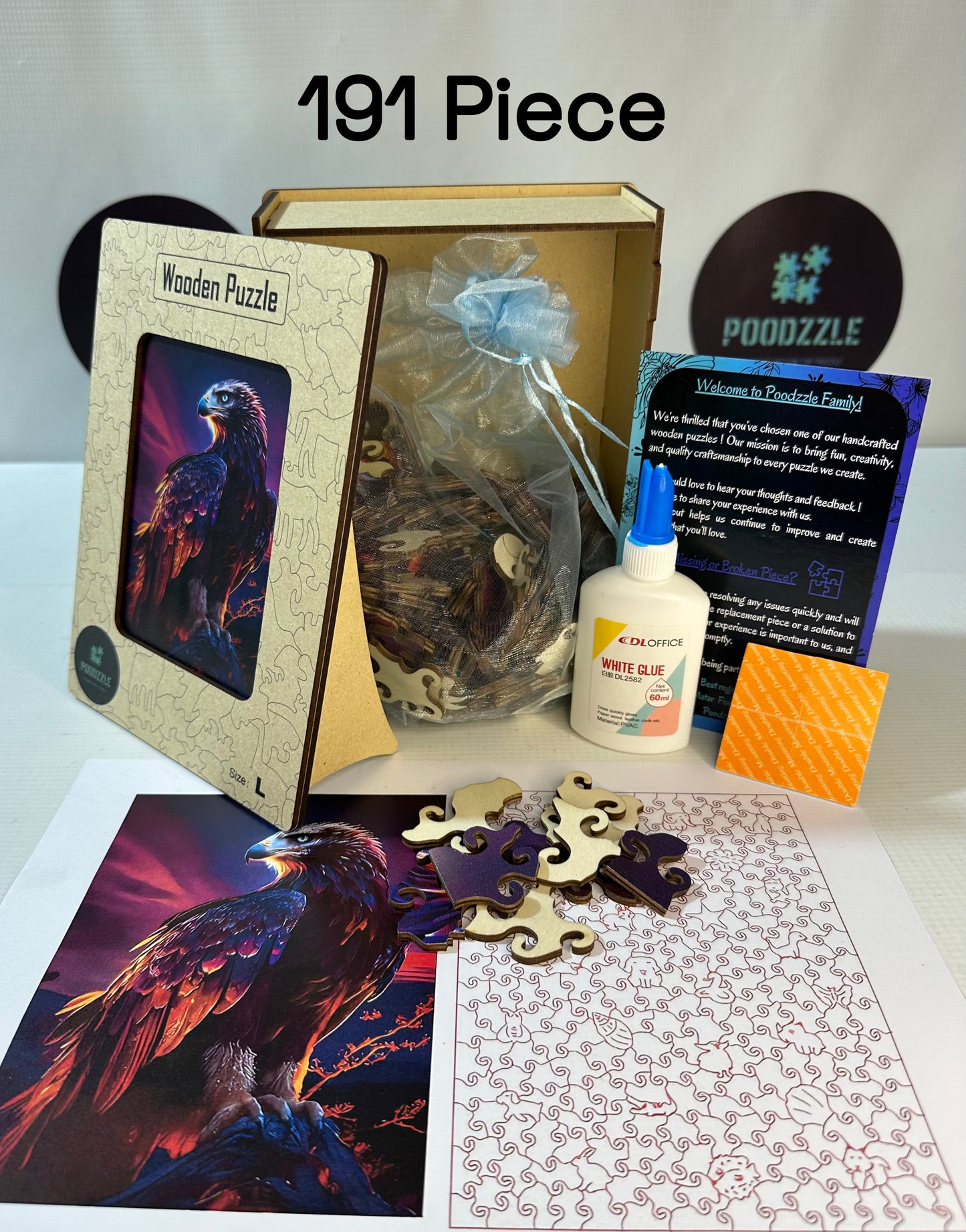 Wooden puzzle set with packaging, glue, and puzzle pieces on a table.