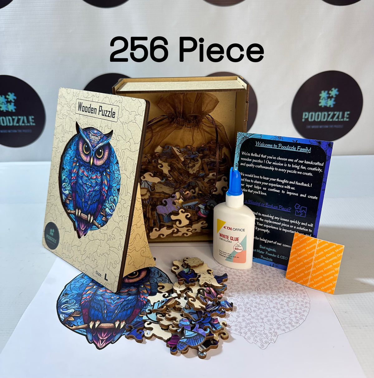 Wooden puzzle with owl design, glue bottle, and packaging on a white surface.